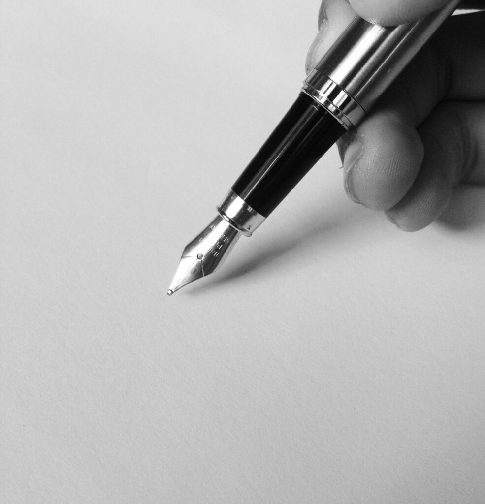 pexels photo 753695 753695 A close-up of a fountain pen writing on blank paper in black and white, capturing elegance.